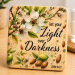 Inspirational wooden coaster featuring the phrase "Let Your Light Over Darkness" with John 16:22 reference, surrounded by elegant almond blossoms, green leaves, almonds, and botanical watercolor accents. Faith-based Christian coaster with natural wood finish and floral artwork, perfect for Christian home décor, religious gifts, Bible study groups, prayer spaces, and daily encouragement.