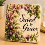 Decorative wooden coaster featuring the inspirational phrase "Saved by Grace" surrounded by elegant watercolor-style plum blossoms, purple fruits, green leaves, and floral branches. Faith-based Christian coaster with botanical artwork and natural wood finish, perfect for Christian home décor, religious gifts, Bible study groups, prayer rooms, and everyday inspiration.